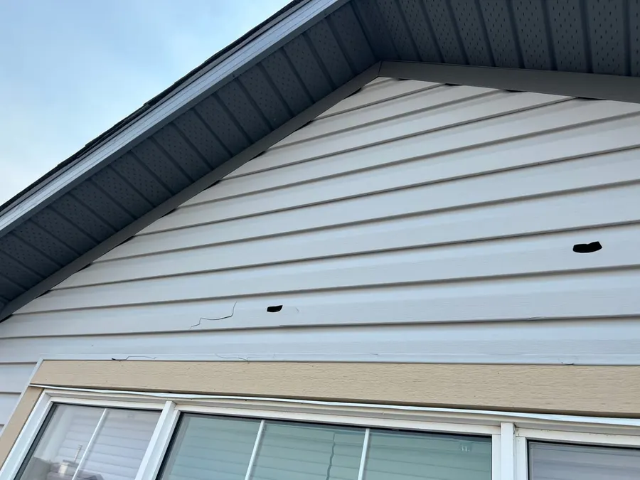 Hail punched two holes through vinyl gable siding